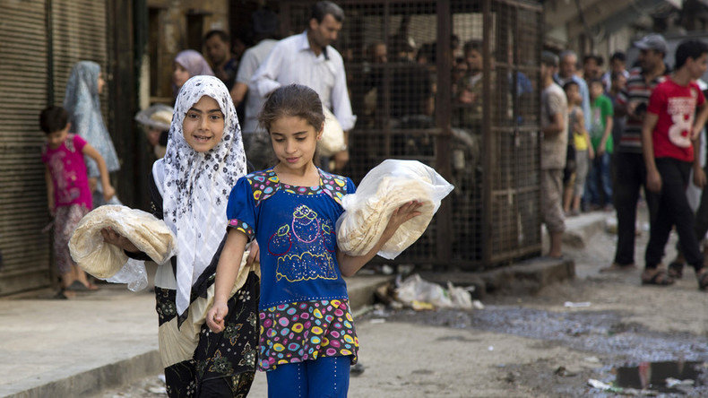 Click to enlarge Syrian girls carry bags with bread in the northern city of Aleppo.