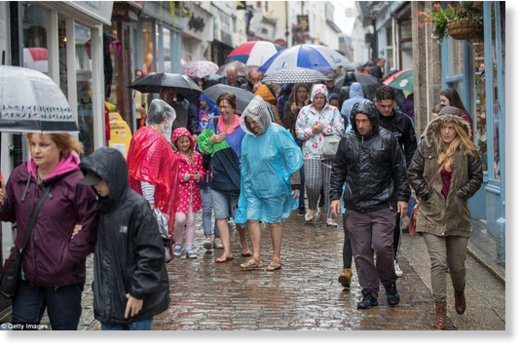 Visitors and residents in St Ives scramble for cover from the rain (pictured) as 'Awful August' gets off to a wet start