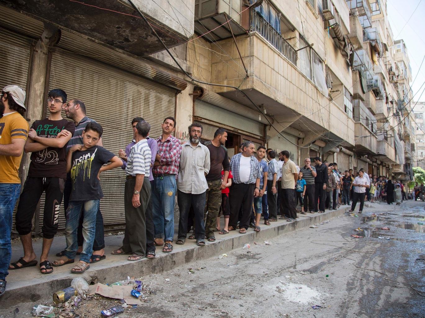 Click to enlarge Syrians queue up to buy bread