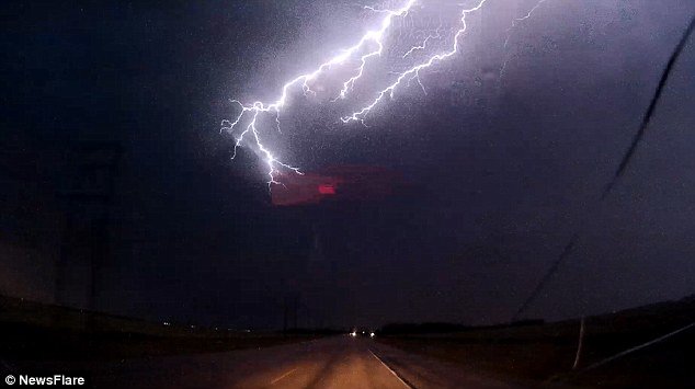 Click to enlarge In the video the driver can be heard screaming as he cruises into the path of the lightning storm
