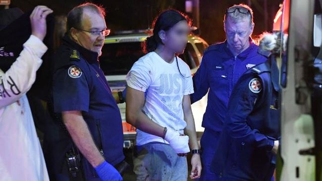 A teen with a hand injury is treated by paramedics before being transported to hospital.