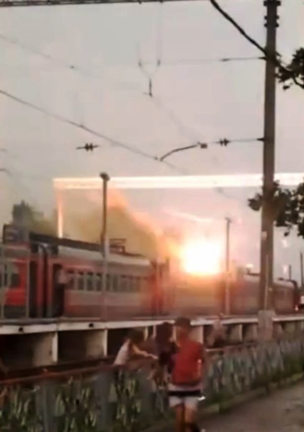 Passengers can be seen running for their lives after the bolt struck struck overhead powerlines seconds before a fire breaks out on the roof 