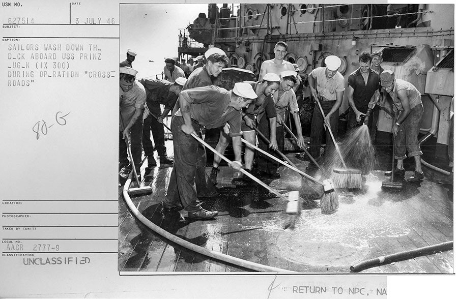 Click to enlarge Group of sailors wash down the highly contaminated deck