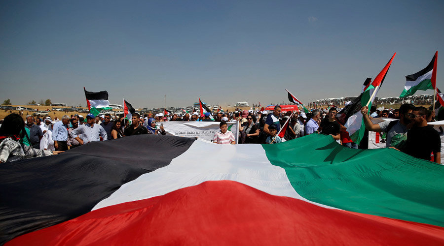 Protesters holding large palestinian flag