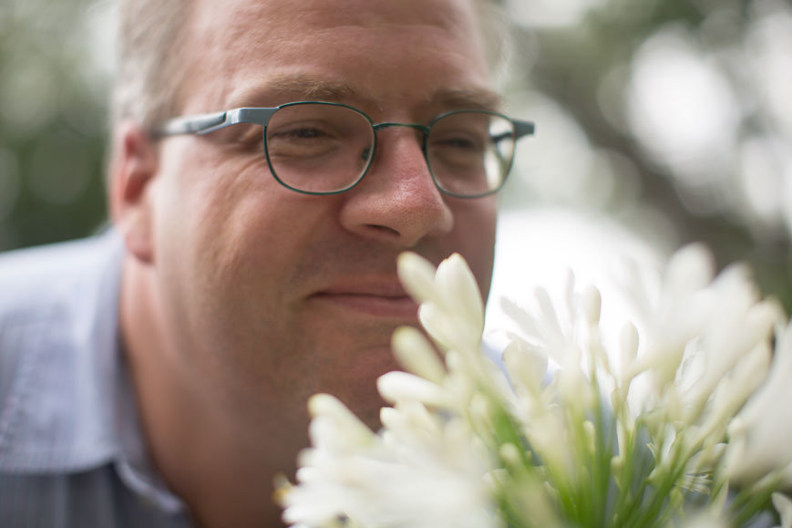man smelling flowers