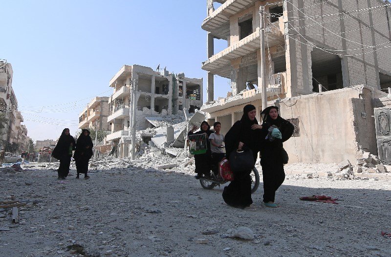 Click to enlarge Woman evacuating Manbij