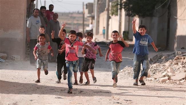 Click to enlarge Children flash victory signs as they play in Manbij, in Aleppo Governorate, Syria