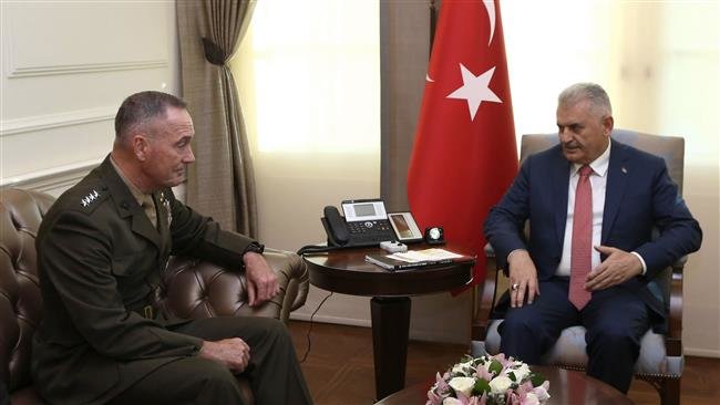 Turkish Prime Minister Binali Yildirim (R) talking with the Chairman of the Joint Chiefs of Staff of the United States, Joseph Dunford (L)