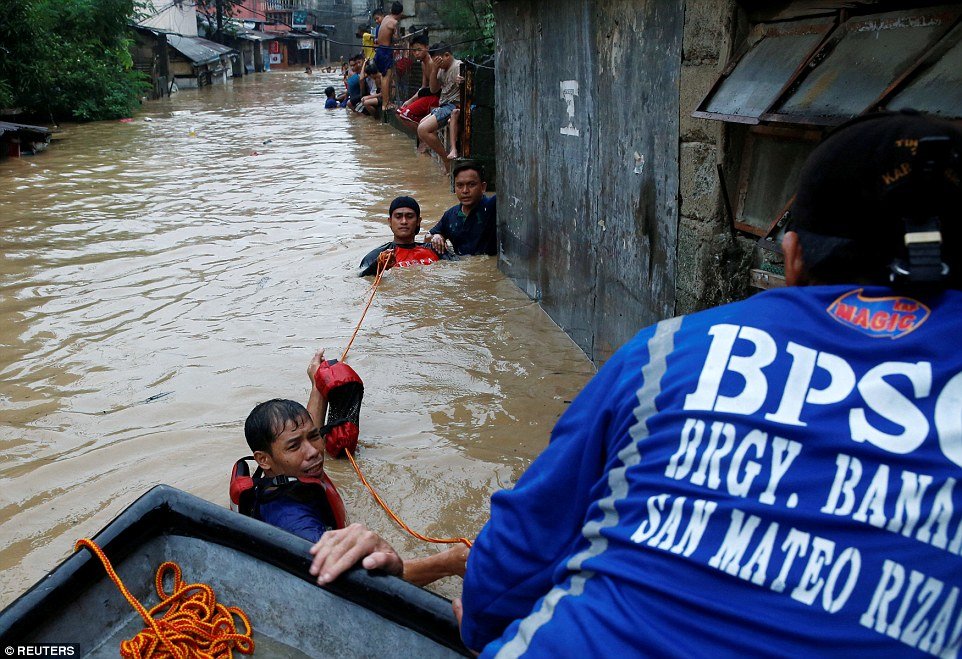 Residents ride on a makeshift boat after evacuating their homes due to the flooding brought on by monsoon rains in San Mateo, Rizal, Philippines. The devastating floods have so far claimed the lives of five people across the country