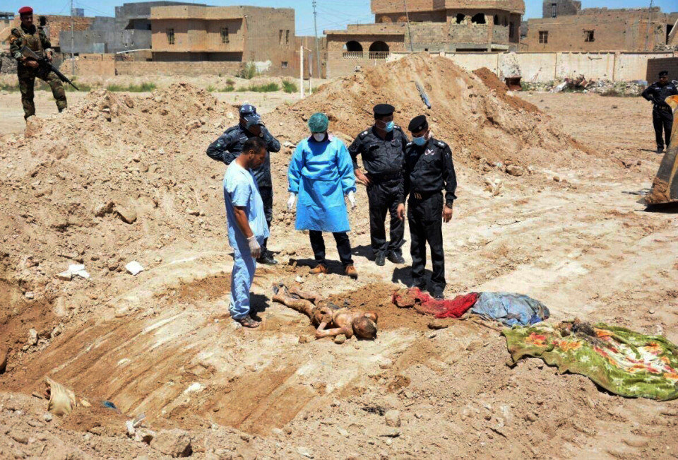 Click to enlarge Iraqi security forces’ forensic team at the site of a mass grave believed to contain bodies of Iraqis