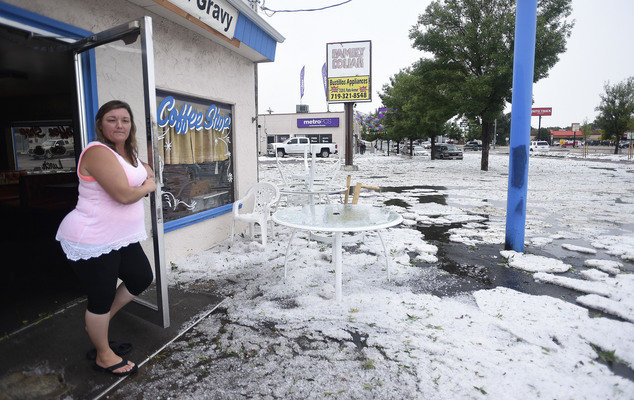 Sharon Miyamoto, owner of Milt's Coffee Shop on E. Platte Ave. looks at a sea of hail outside her shop after a storm Monday, Aug. 29, 2016, in Colorado Springs, Colo. 