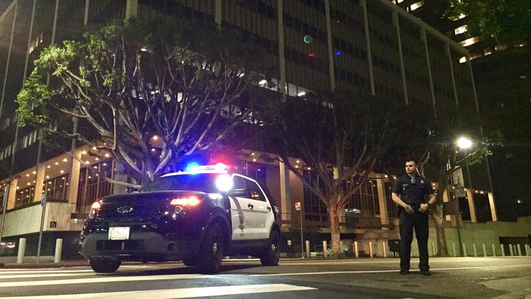 A Los Angeles police officer keeps watch at Temple and Los Angeles streets