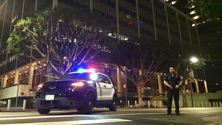 A Los Angeles police officer keeps watch at Temple and Los Angeles streets