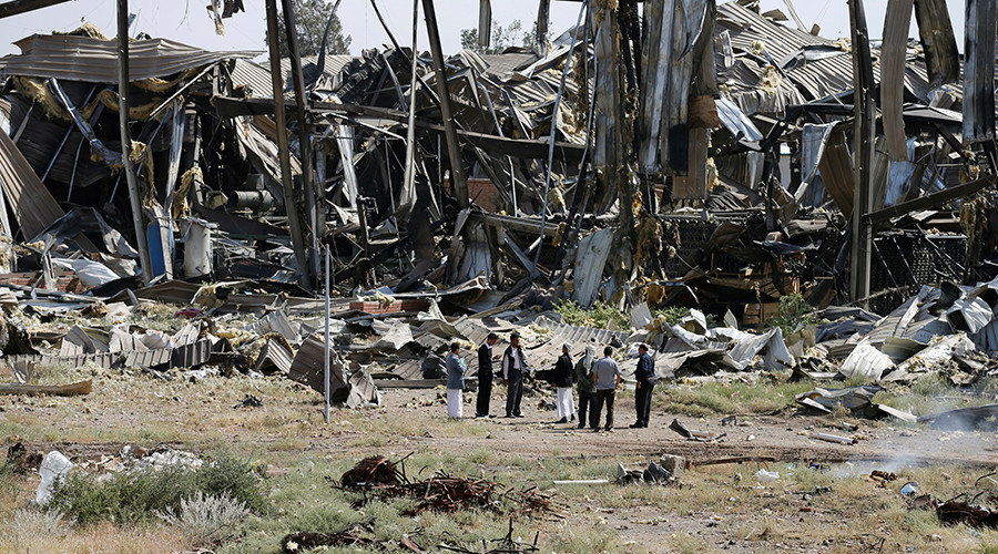 Workers and journalists inspect damage at the Yemen Alsonidar Group's water pumps