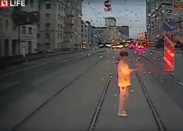 Suddenly she looks up as the tram approaches and is caught in the glare of headlights