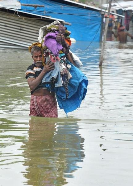 Click to enlarge Man carries his belongings along a flooded street, following heavy rain in Nijampet, a low lying area on the outskirts of Hyderabad on September 21, 2016.