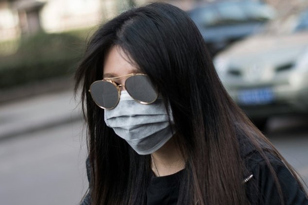 A woman wearing a face mask during a yellow alert for air pollution in Beijing on March 18, 2016 