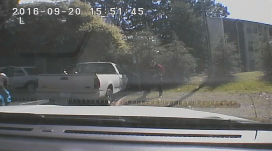 Keith Scott (L) falls after being shot
