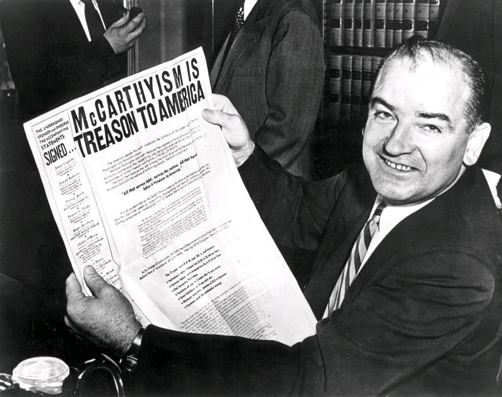 McCarthy holding newspaper
