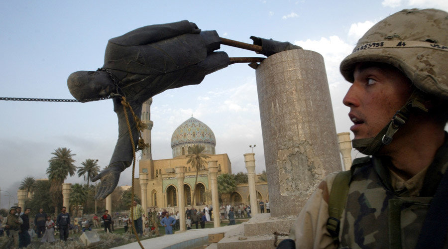 A U.S. soldier watches as a statue of Iraq's President Saddam Hussein falls in central Baghdad, Iraq April 9, 2003