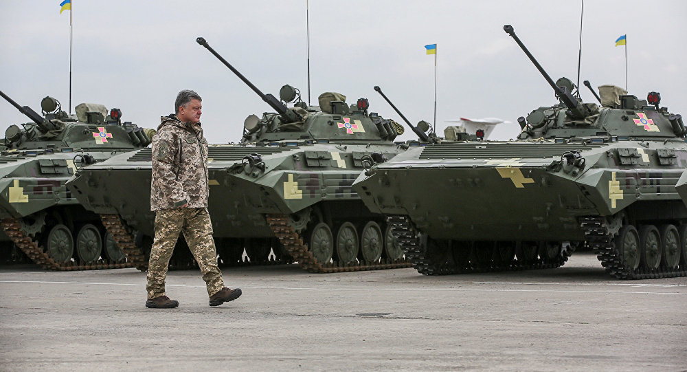 Click to enlarge Petro Poroshenko walks past tanks