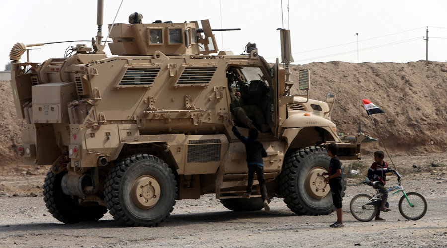 Click to enlarge U.S army soldier speaks with children in Qayyarah