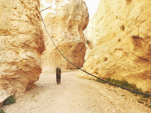 Resident walking through crevice to St. Thelka