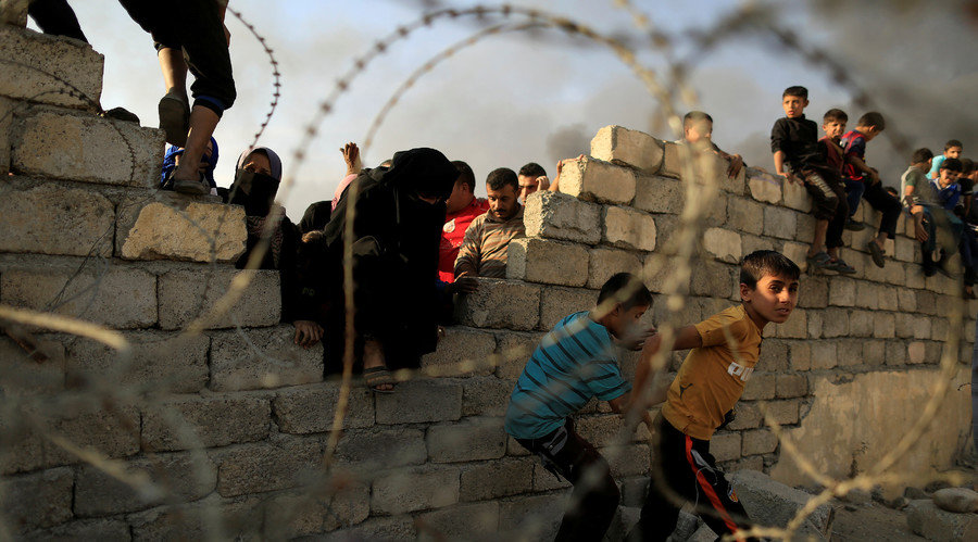 displaced people run after they jumped over a wall