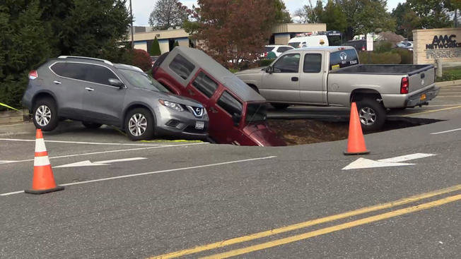 The Nassau County police found these three vehicles tipped, or nearly so, into a sinkhole that opened up Friday, Oct. 28, 2016, near Hicksville Road and Harrison Avenue in Bethpage.
