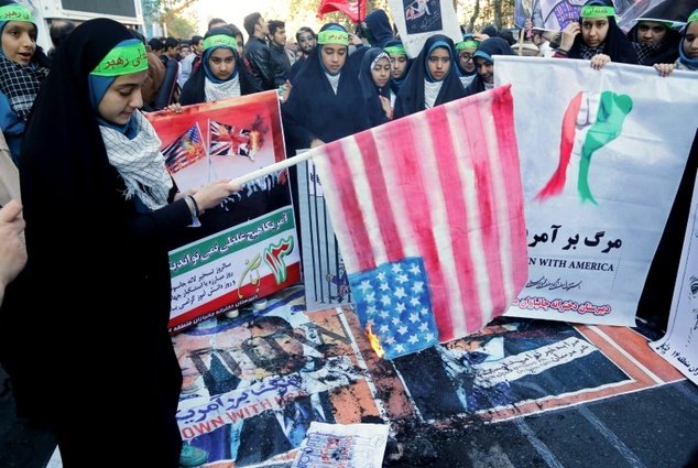 Iranian youth burns home-made American flag outside the former US embassy Tehran