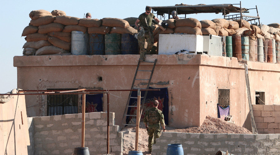 Click to enlarge A U.S. fighter walks down a ladder from a barricade, north of Raqqa city, Syria