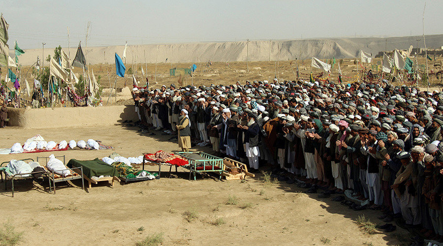 Afghans perform prayers at the funeral for the victims killed by an air strike