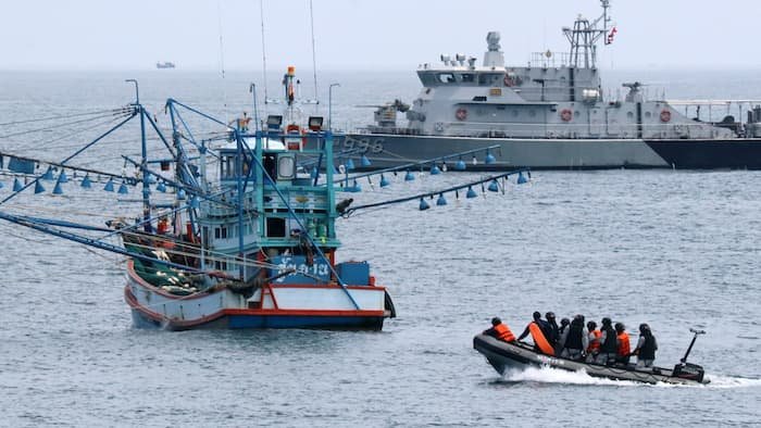 Click to enlarge A Thai naval vessel, right, approaches a fishing boat for an inspection in the Gulf of Thailand on October 19.