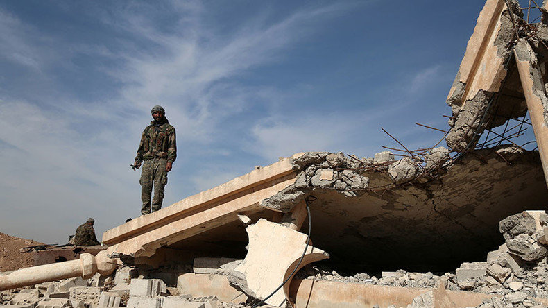 Click to enlarge An Syrian Democratic Forces (SDF) fighter stands with his weapon on the rubble of a destroyed building, north of Raqqa city, Syria