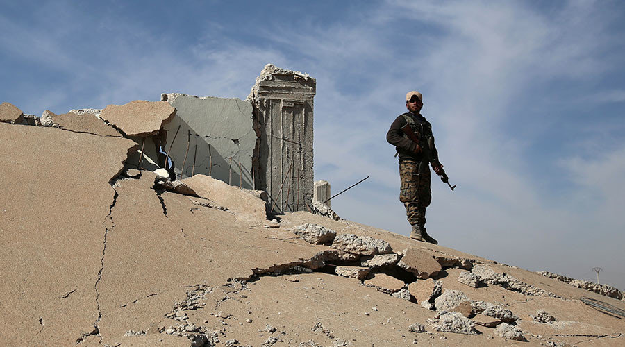 Click to enlarge An Syrian Democratic Forces (SDF) fighter stands with his weapon on the rubble of a destroyed building, north of Raqqa city, Syria