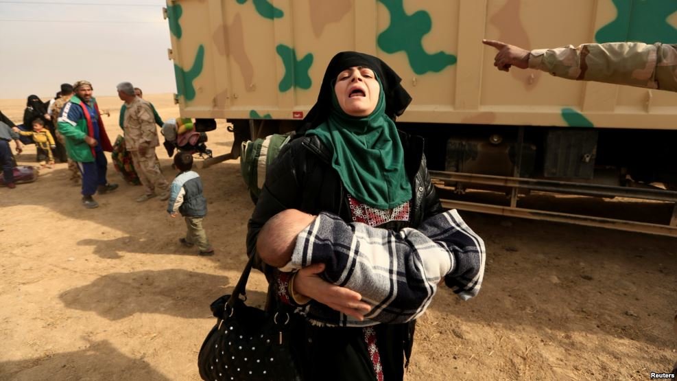 Click to enlarge woman fleeing fighting between Islamic State militants and Iraqi forces
