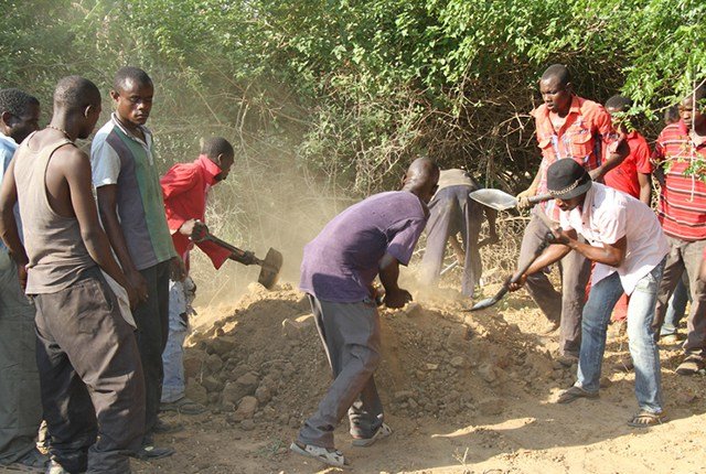 Click to enlarge Villagers bury Owen Chianga’s remains after he was killed by a crocodile while fishing in Save River.