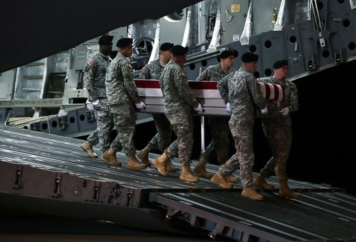 Army soldiers move the flag-draped remains