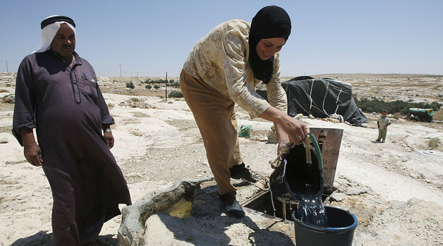 Palestinians getting water from well