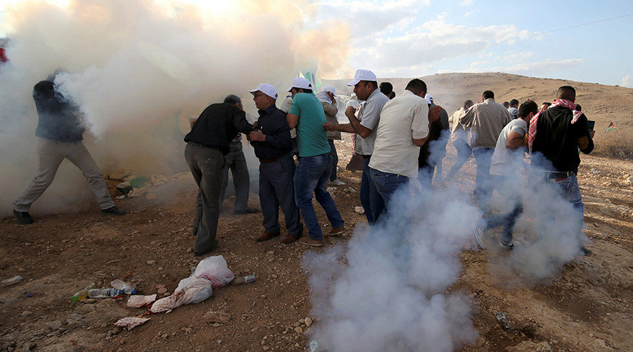 Palestinian demonstrators react to tear gas fired by Israeli troops during a protest against Jewish settlements in Jordan Valley near the West Bank city of Jericho November 17, 2016