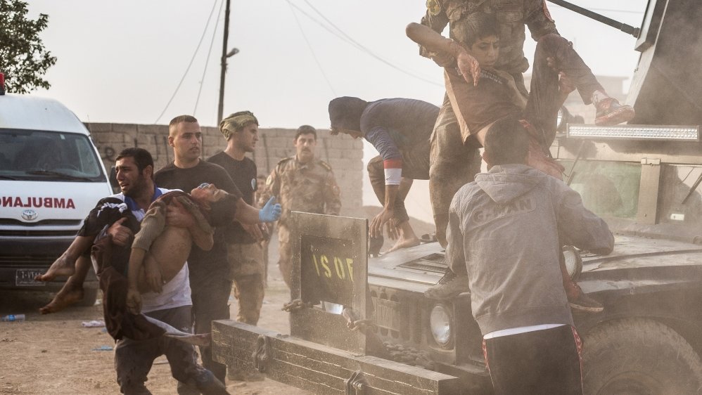 Mohammed, 12, and a 15-year-old neighbour are carried from an Iraqi army Humvee at an outdoor field clinic in Mosul's Samah district. The boys were hit in a mortar attack that shredded Mohammed's leg and killed Shafiq