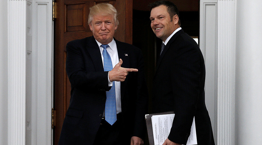U.S. President-elect Donald Trump stands with Kansas Secretary of State Kris Kobach