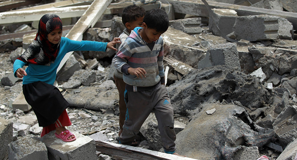 Yemeni children walk amidst the rubble of a house in Yemen's Huthi rebel-held capital Sanaa