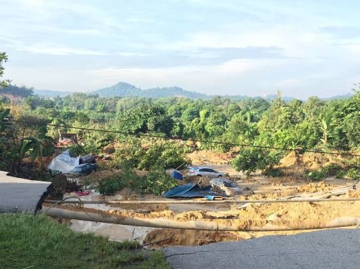 Click to enlarge At least six cars, two motorcycles and one van were swallowed up by earth in the 1.20am incident.