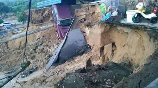 Click to enlarge At least six cars, two motorcycles and one van were swallowed up by earth in the 1.20am incident.