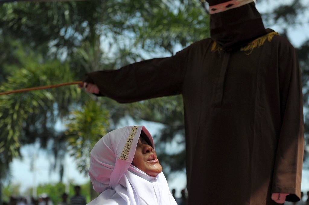 Click to enlarge religious officer canes a woman