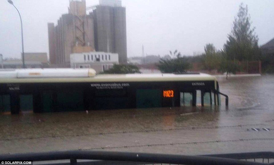 A bus is half-submerged by the muddy floodwaters. Many people have had to abandon their cars in the streets, unable to finish their journeys 