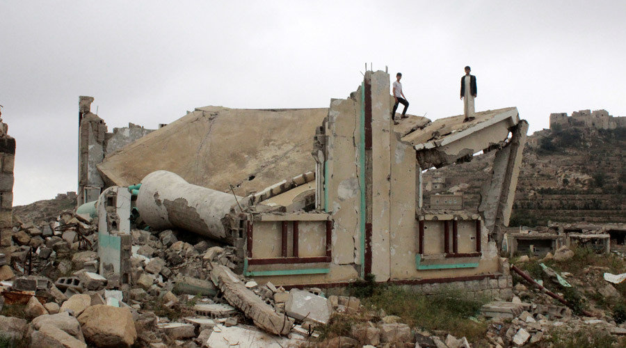 Boys stand on the collapsed roof of a Yemen mosque