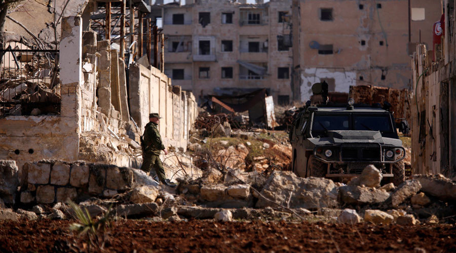 A Russian soldier walks to a military vehicle in goverment controlled Hanono housing district in Aleppo, Syria