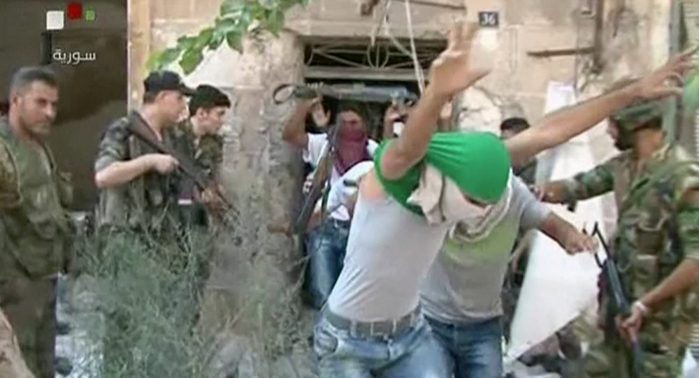 This still image from Syrian state TV video, shows young men with their faces covered surrendering to government forces, in Aleppo, Syria, Saturday, July 30, 2016